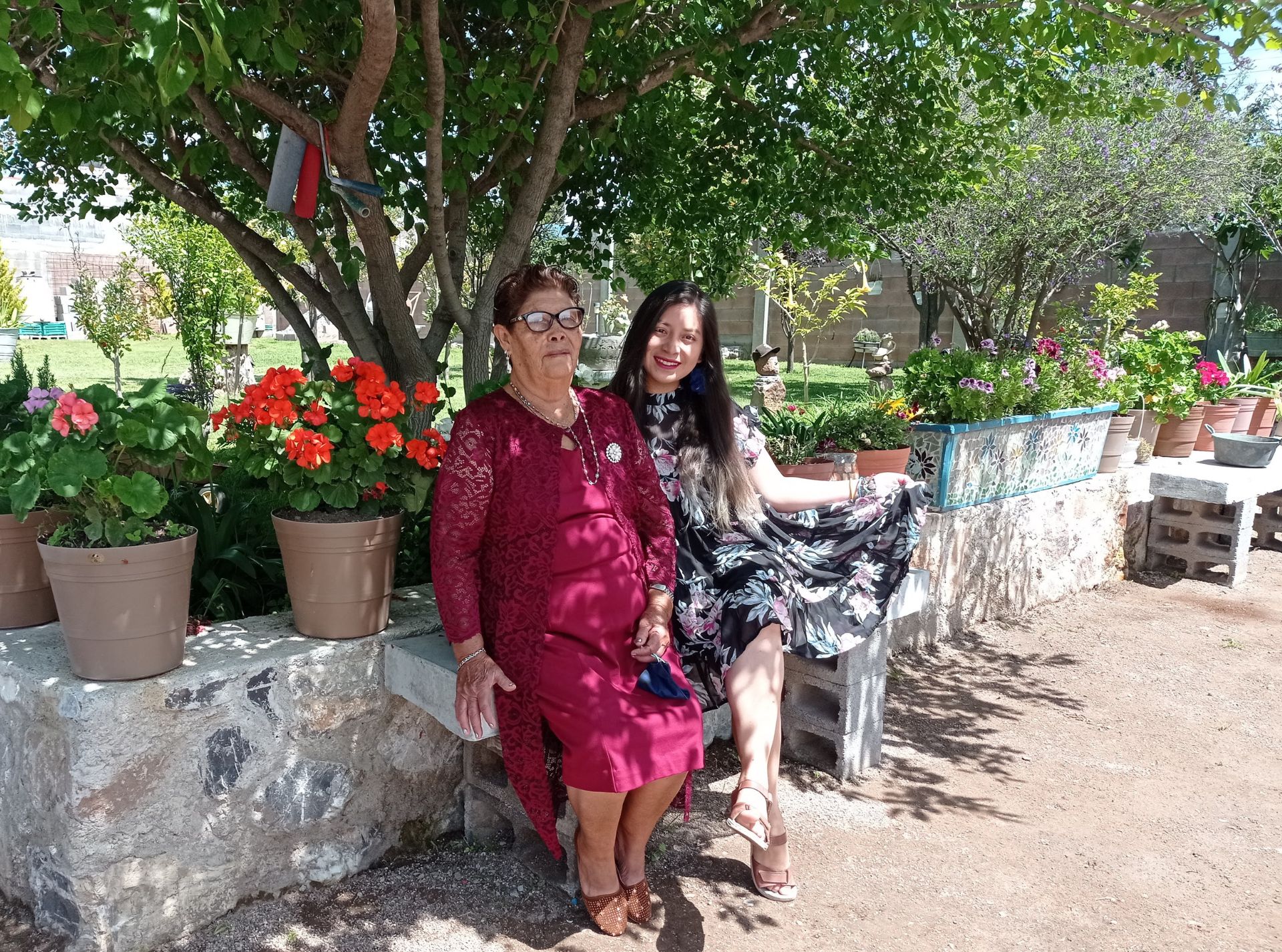 Dos mujeres sonrientes con vestido elegante en medio de arboles y naturaleza