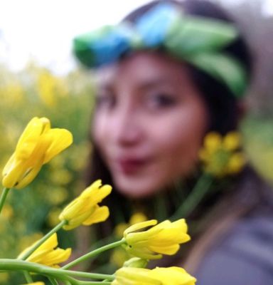 Flores amarillas y de fondo una mujer sonriendo