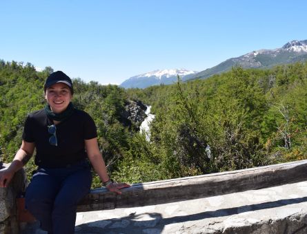 Paisaje natural con uchos arboles y una mujer sentada en el borde