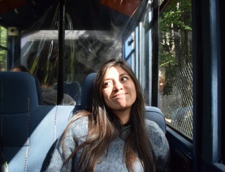 mujer sonriendo y mirando arriba mientras viaja en tren del fin del mundo